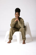 Charger l'image dans la galerie, She is on a chair laughing wearing a really comfortable forest sage green lounge set thats textured and stretch in a corduroy fabric
