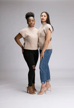 Load image into Gallery viewer, Two females they are wearing jeans nude heels and sleeveless turtleneck sweaters with shoulder pads. they look elegant. The sweaters are a light latte colour
